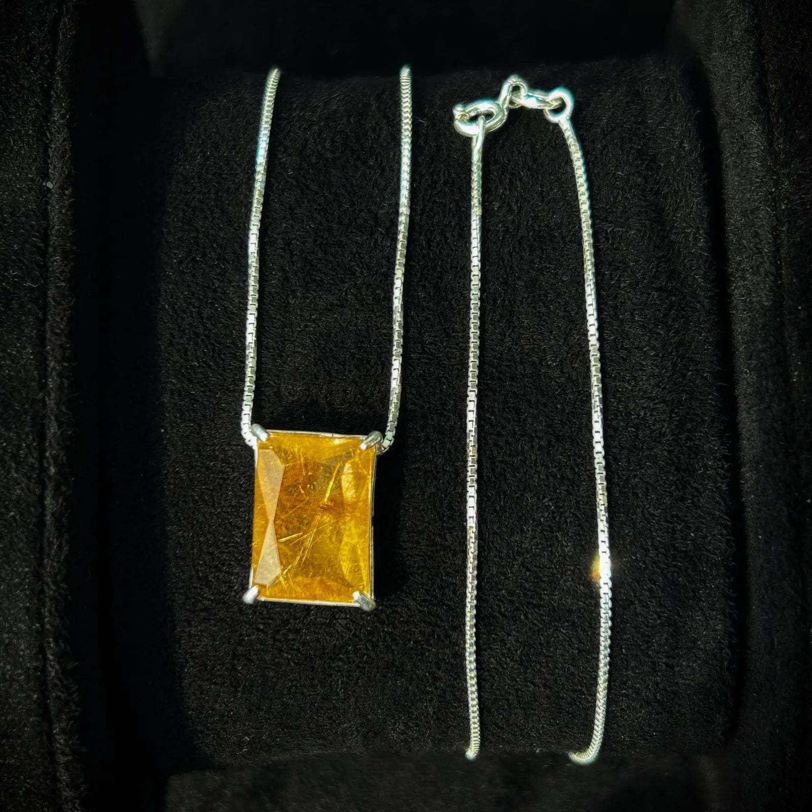 Colar Luce Che Guida com pingente de quartzo rutilado dourado e corrente veneziana em prata 925 maciça, exibido em uma caixa de joias. A peça perfeita para presente.